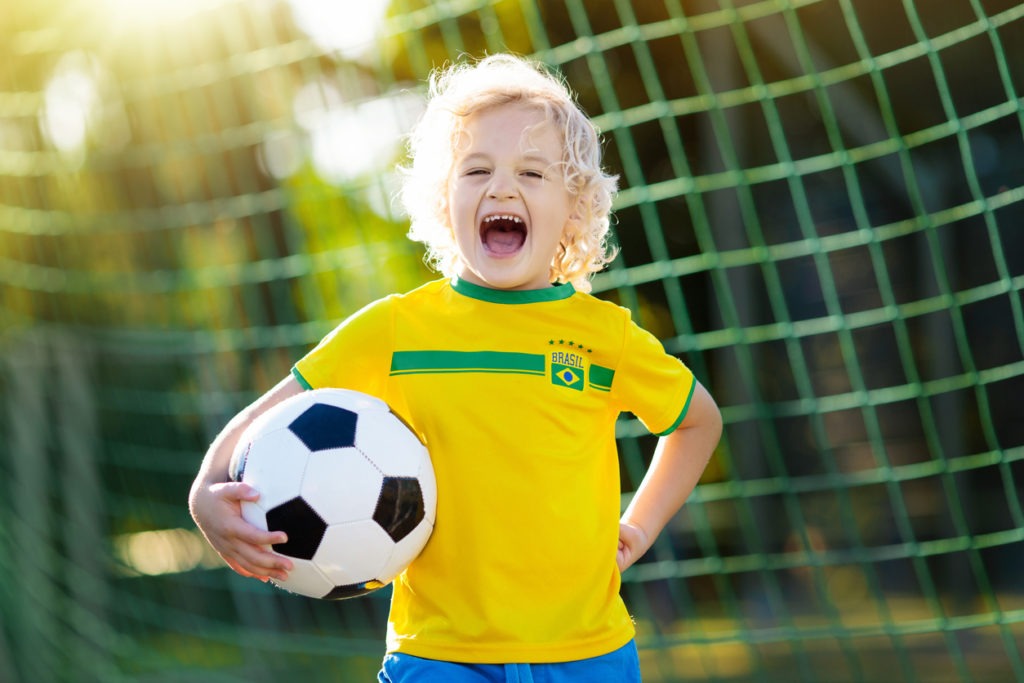 Unge med fotballdrakt i ballbinge